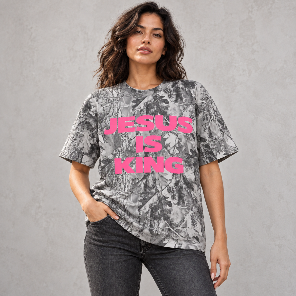 Close-up of the pink JESUS IS KING print on gray leaf camo fabric