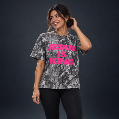 Smiling woman in a JESUS IS KING pink camo tee and black leggings